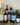 Collection of wine bottles on a table with candles and decorative items.