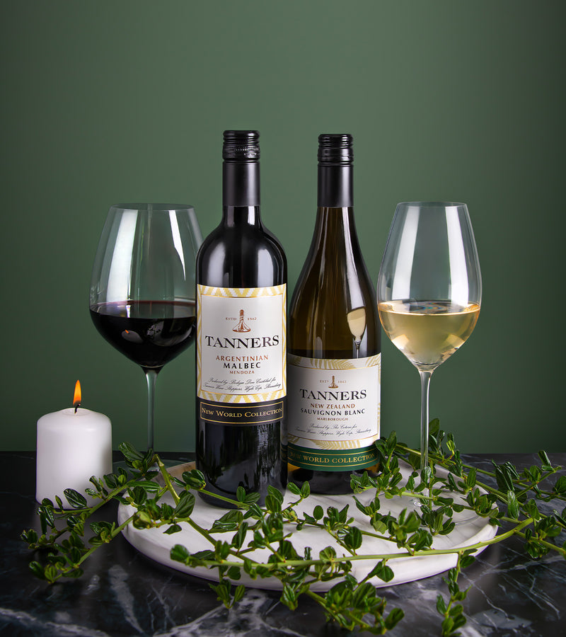 Two bottles of Tanners wine with glasses on a marble tray against a green background