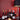 Collection of wine bottles on a table with a red wall and lamp in the background
