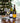 Two wine bottles and two glasses on a tray with a Christmas tree in the background