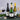 Three wine bottles and glasses on a dark surface with a grey textured background