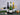 Three wine bottles and glasses on a dark surface with a grey textured background