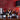 Collection of wine bottles on a wooden cabinet with a red wall background