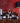 Collection of wine bottles on a wooden cabinet with a red wall background