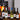 Collection of wine bottles on a table with a fireplace in the background
