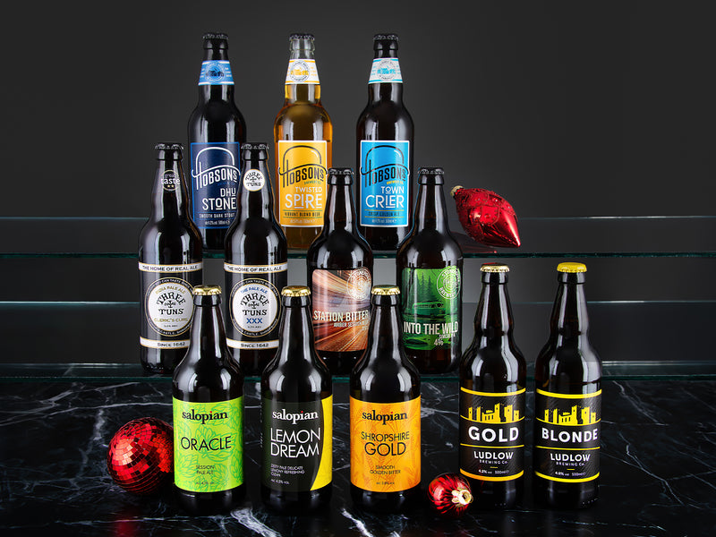 Collection of various Shropshire ale bottles on a dark surface with a black background