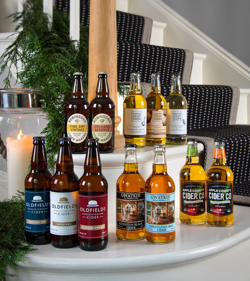 Assorted bottles of cider on a staircase with decorative elements.