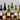 Collection of wine bottles with labels on a reflective surface with candles in the background
