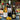 Three wine bottles including a French Sauvignon Blanc, Douro Red and Tanners Prosecco, alongside two wine glasses on a decorated dining table with a plaid tablecloth, candles, olives, and a Christmas tree in the background.