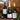 Three bottles of Tanners wine and champagne including a Super Claret, White Burgundy and Tanners Extra Reserve displayed on a wooden shelf with evergreen branches and a small candle, set against a rustic wood-paneled wall.